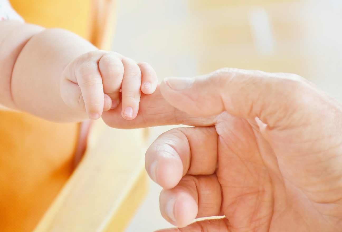A happy parent holding the hand of a newborn baby at Australia's Top IVF Centres,