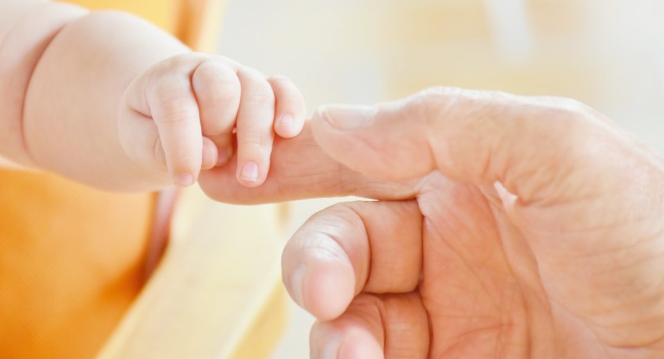 A happy parent holding the hand of a newborn baby at Australia's Top IVF Centres,